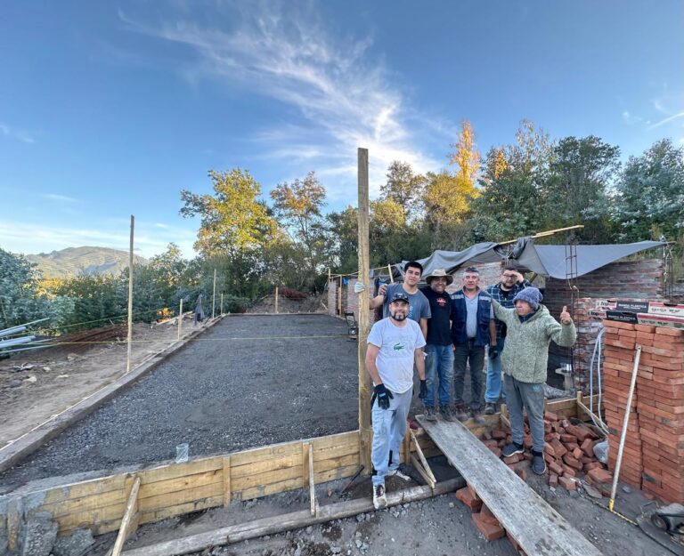 Team posing at the newly poured foundation